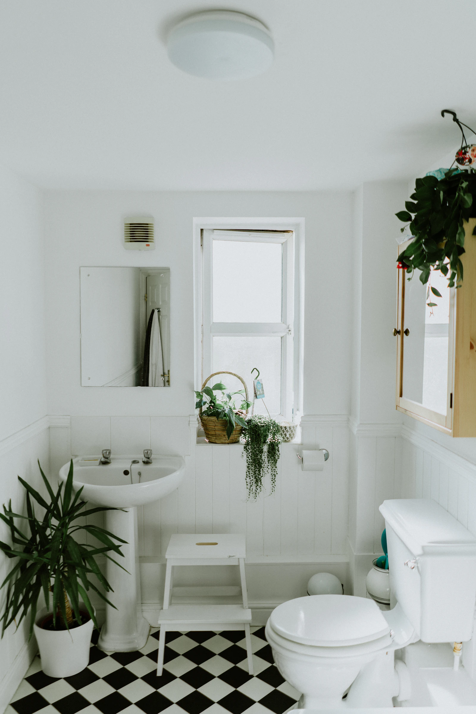 A bathroom corner being checked with a moisture meter